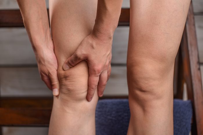 Woman in pain holding her knee