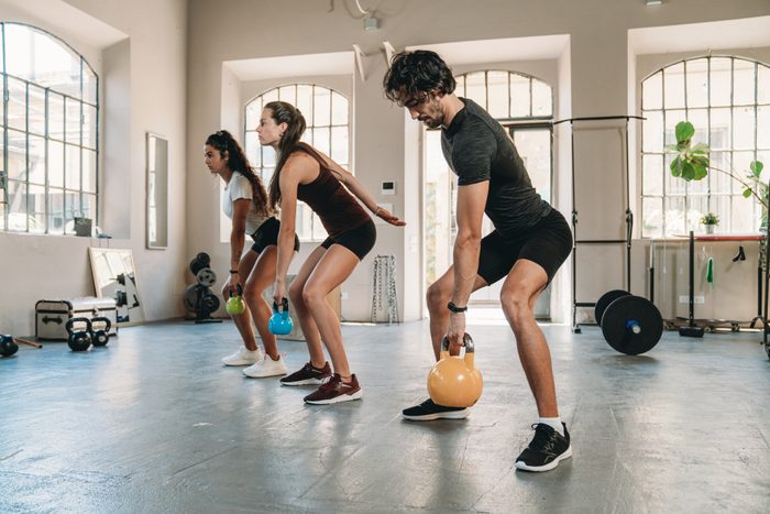 People are doing exercises with kettlebells together