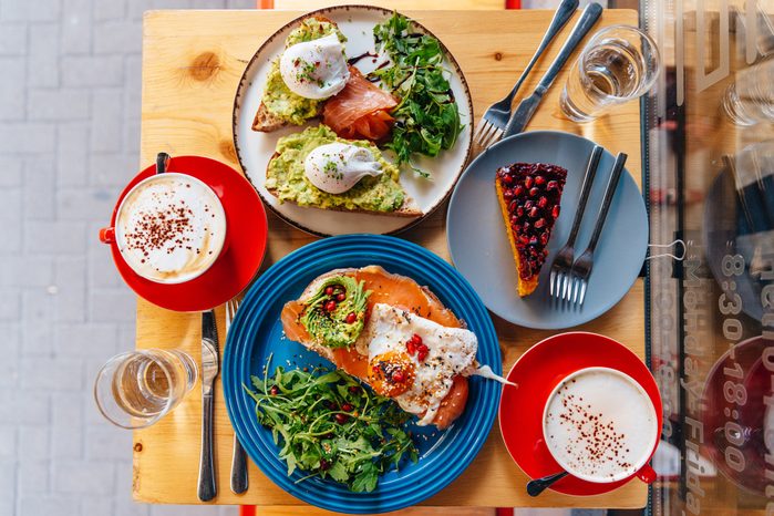 Brunch with avocado toasts, salmon, poached eggs and coffee at the restaurant