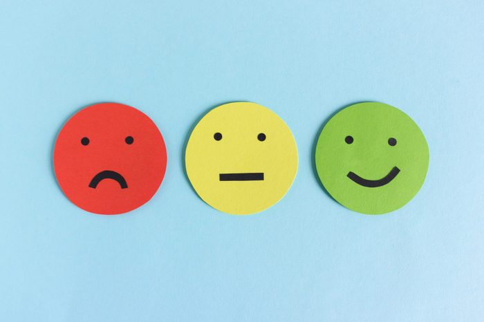 Row of three colorful smileys for expressing satisfaction, dissatisfaction and indifference composed on blue background 