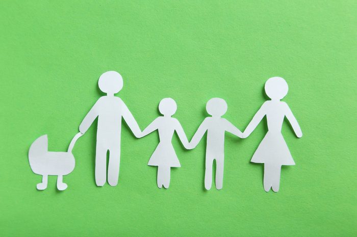 Happy paper family on green background