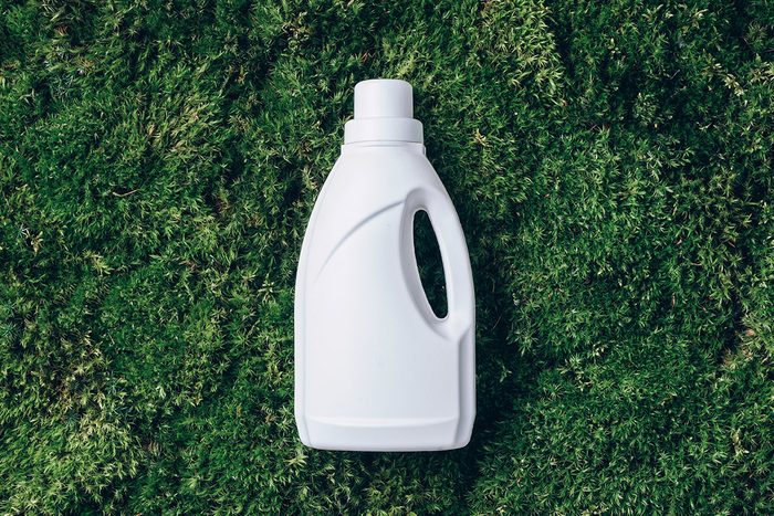 White Plastic Bottle of laundry detergent on a green grass background