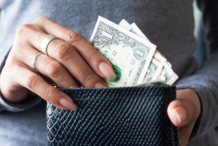 Midsection Of Woman Holding Wallet With Paper Currency