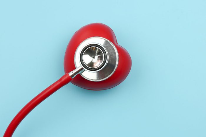 High Angle View Of Red Heart Model With Stethoscope Over Blue Background