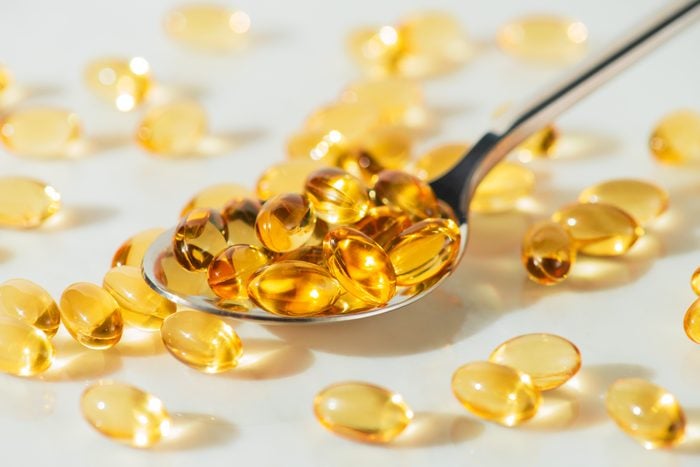 Food supplement Omega 3 in a spoon, medical supplements and vitamins D
