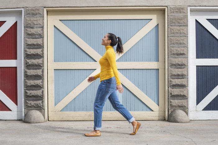Woman walking by colorful doors outside