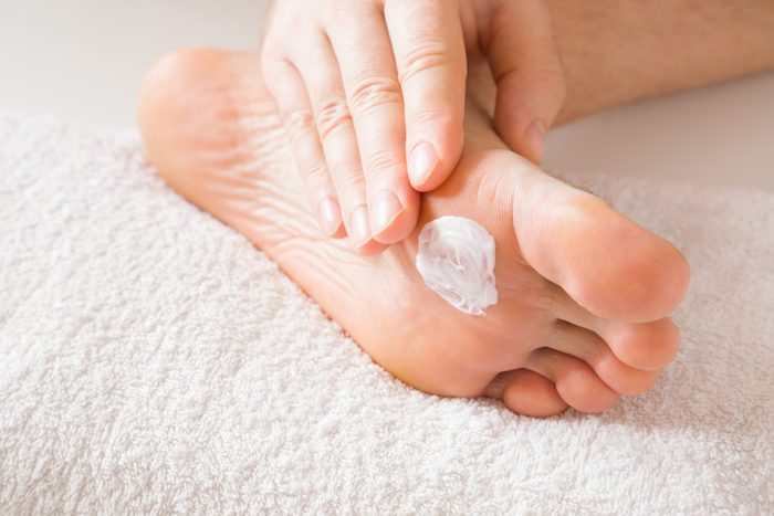 hand putting lotion on a foot