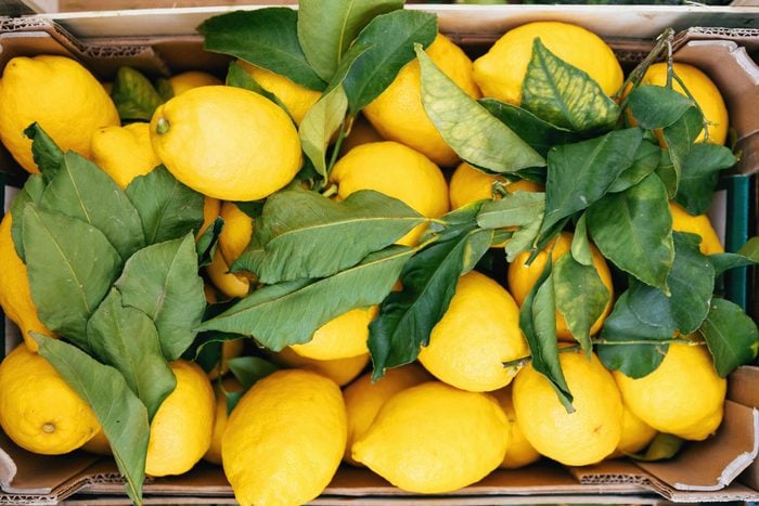 fresh Lemons with leaves in a crate