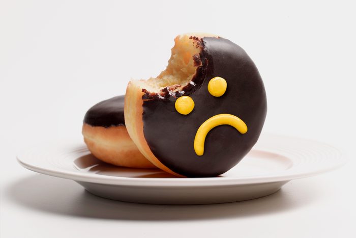 donut with a sad face in yellow frosting