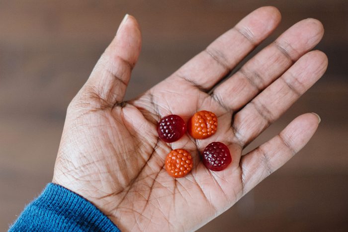 Woman Holds Gummies In Palm Of Her Hand