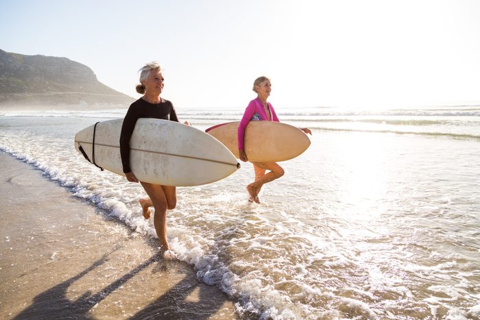 Senior women going for a morning surf in the sea