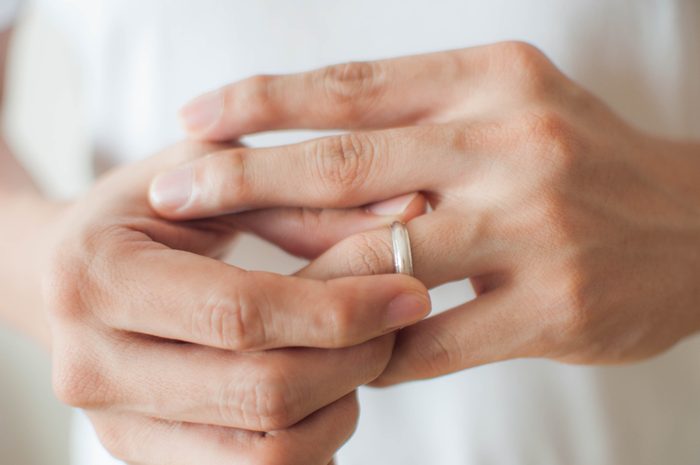 A young man is removing his wedding ring a concept of relationship difficulties