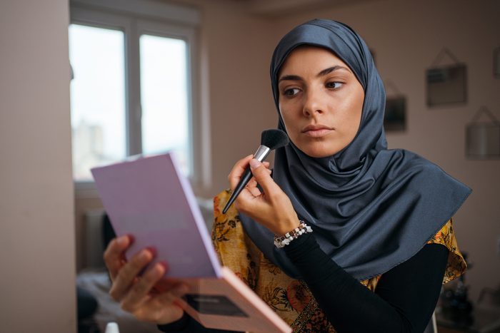 Beautiful Muslim woman applying make up