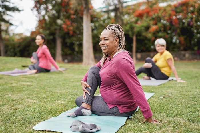 Multiracial women doing yoga and exercising outside to help maintain a healthy lifestyle and prevent Macular Degeneration
