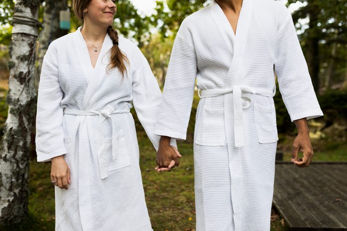 Couple in bathrobes holding hands