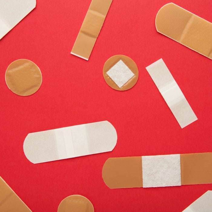 Set of adhesive plasters on red background