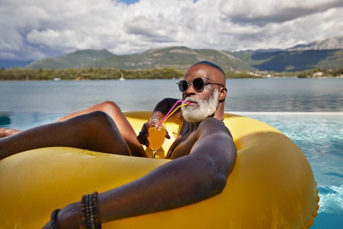 Man drinking juice in inflatable ring