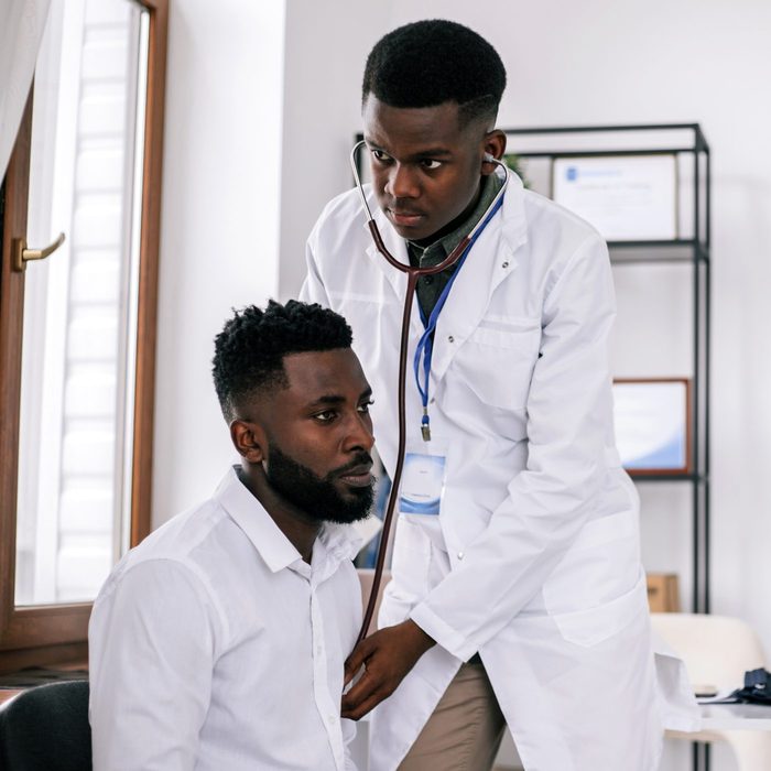Young African man having an African-american man doctor's appointment.