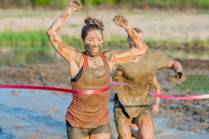 woman running in a mud run during the summer