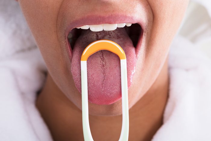 Woman Cleaning Tongue