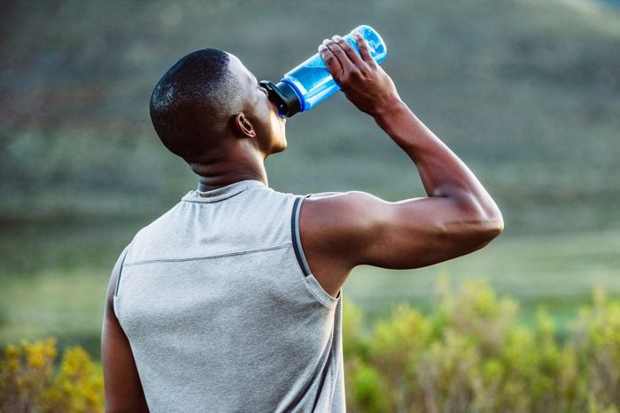 man hydrating during a workout in the summer time