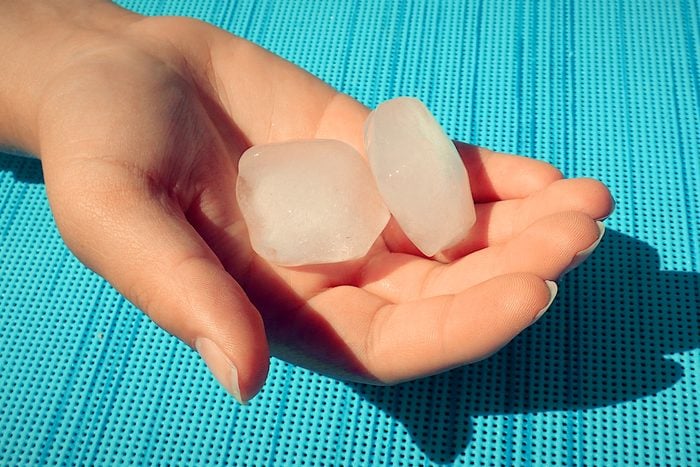 hand holding two ice cubes to For Temperature Play During Sex In The Summer