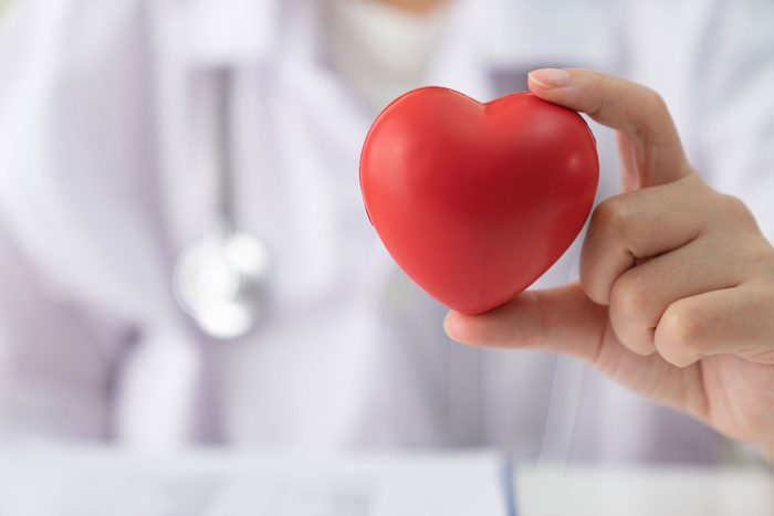 an anonymous doctor holds up a heart shaped stress ball