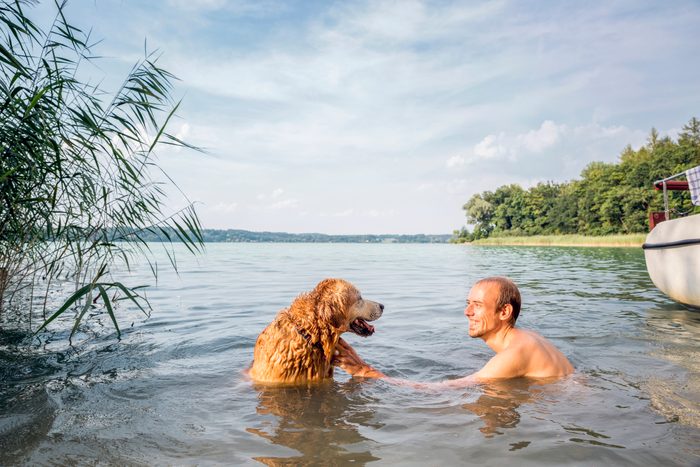 Young man with his Golden Retriever in a lake