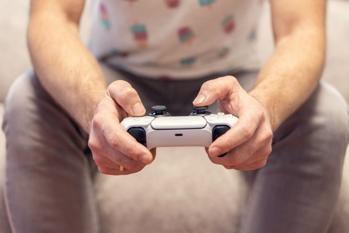 man playing video game console on the sofa at home