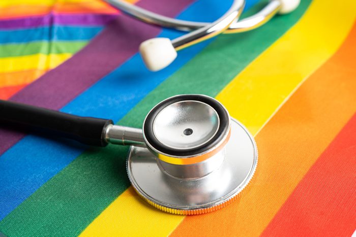 Black stethoscope on rainbow flag background, symbol of LGBT pride month celebrate annual in June social, symbol of gay, lesbian, bisexual, transgender, human rights and peace.