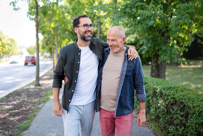 father and son walking together on a sidewalk