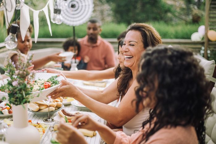 Cheerful Family In Dinner Party At Backyard