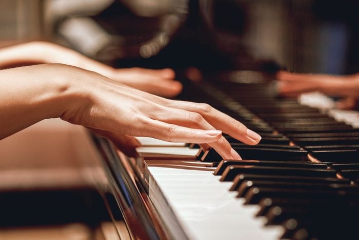 close up of hands playing piano