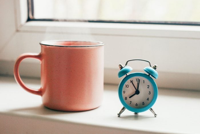 pink coffee mug and teal alarm clock