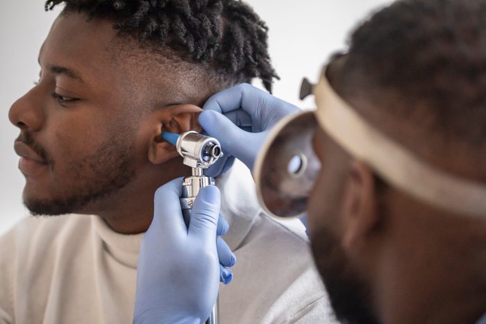Close up of a doctor checking the ear of his male patient