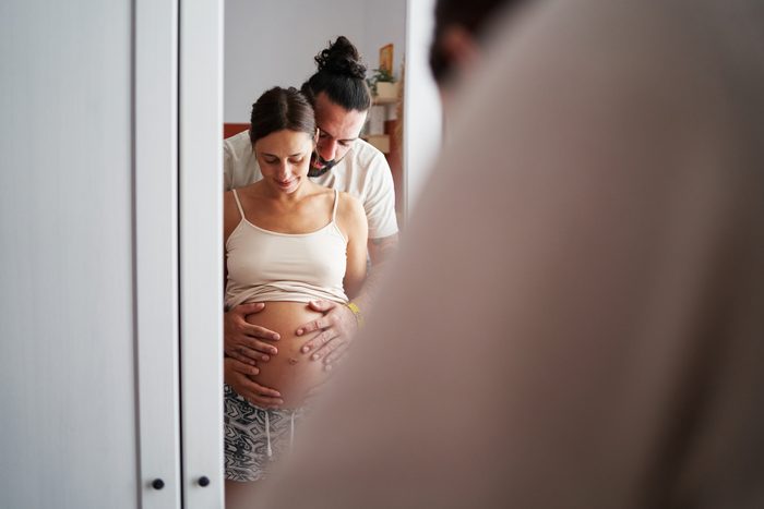Pregnant woman and her partner embracing.