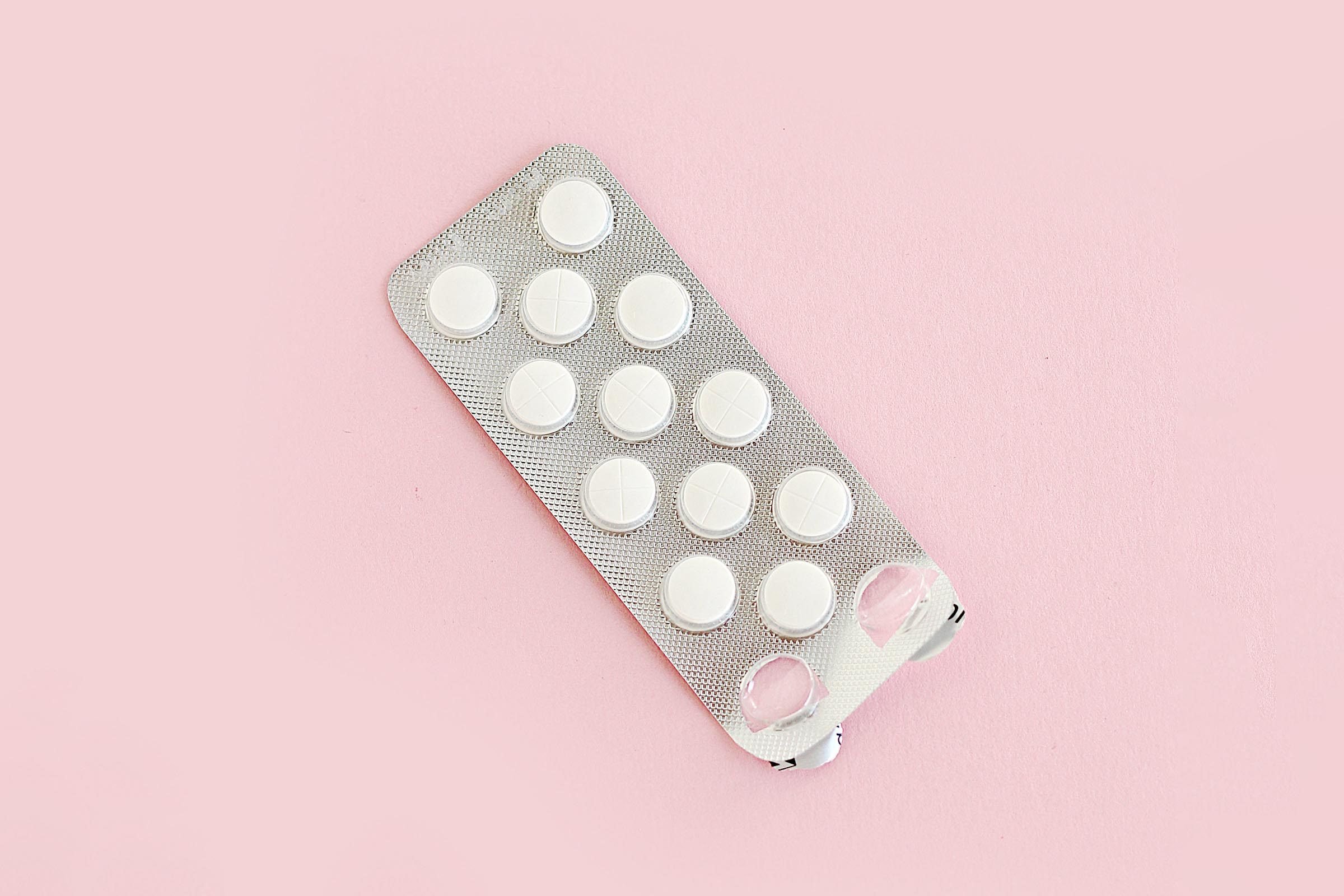 blister pills on a pink background