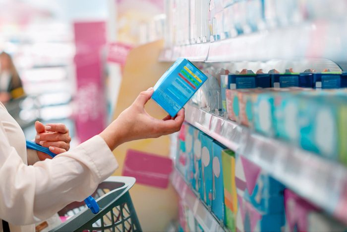 Woman choosing sanitary pads in the supermarket