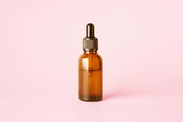 bottle of tea tree oil on pink background