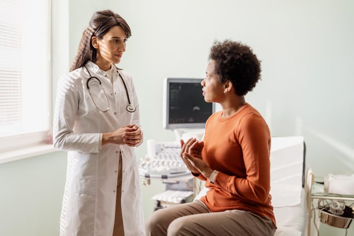A female doctor talks with her patient in front of her