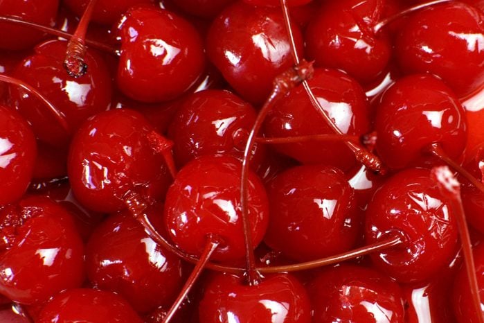 Close-up of glossy red maraschino cherries with stems