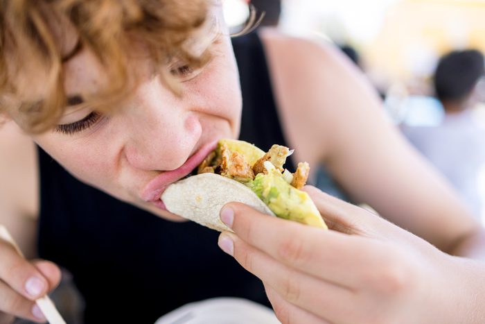 teenage boy eating a taco