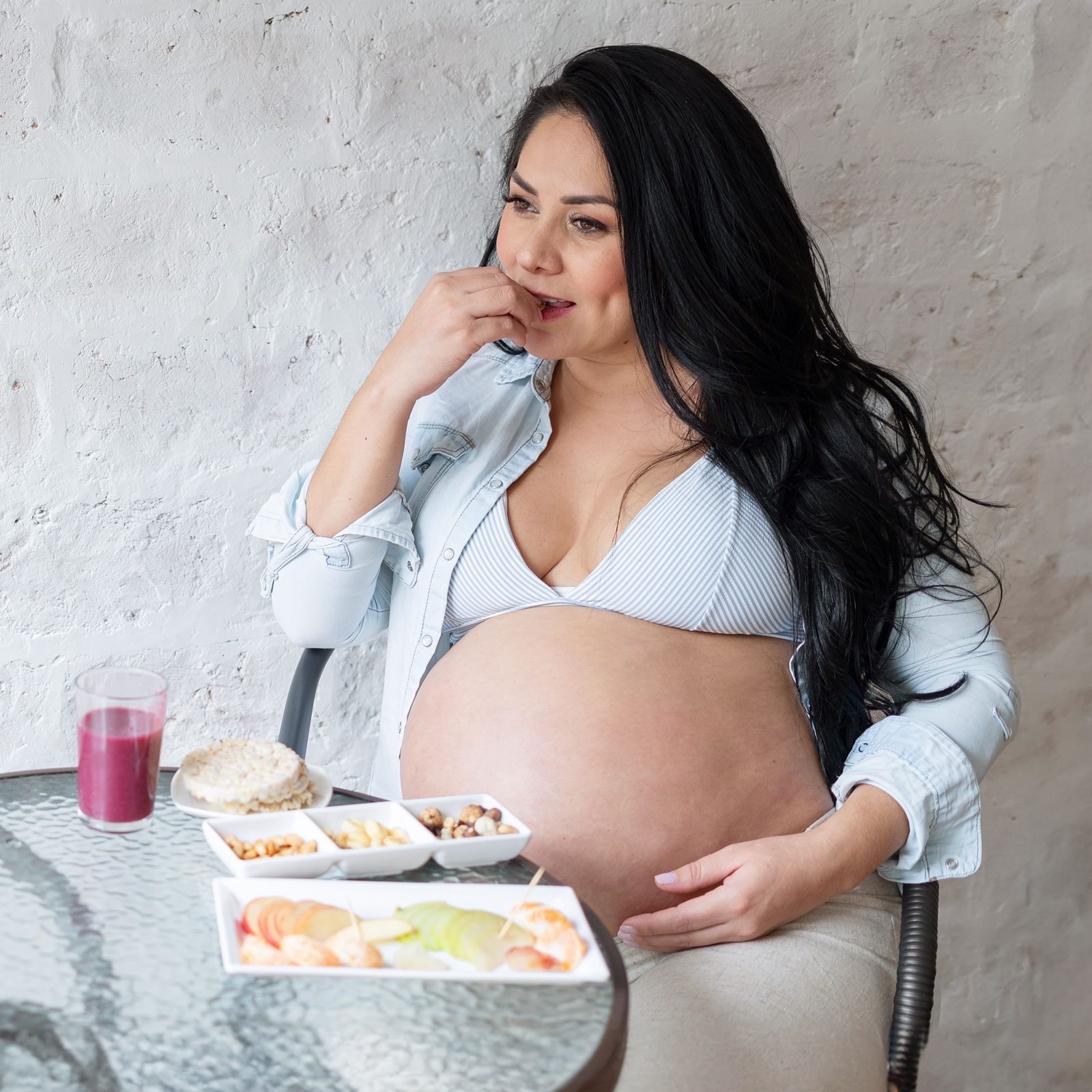 pregnant woman eating lunch at an outdoor table