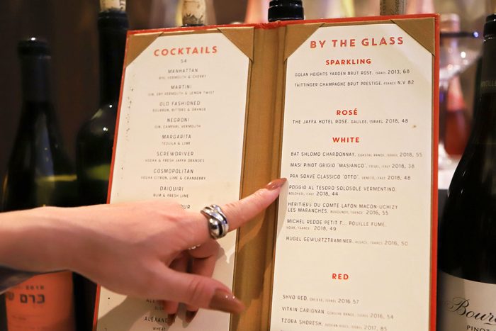 hand touching a restaurant drink menu