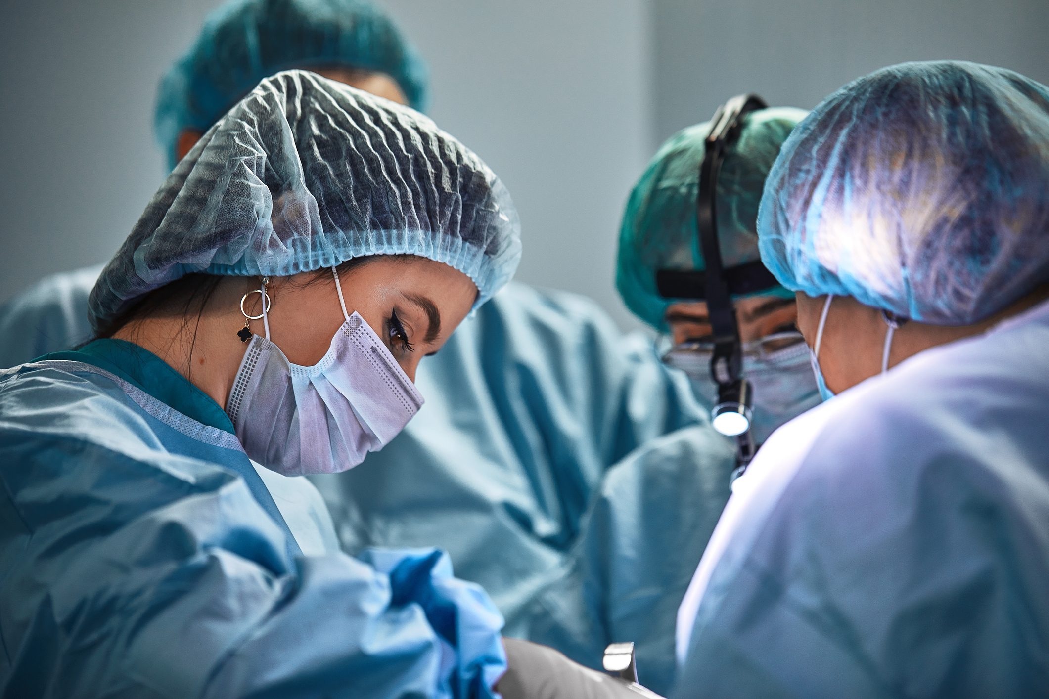 In the hospital operating room. An international team of professional surgeons and assistants works in a modern operating room. Professional doctors celebrate successfully saved lives