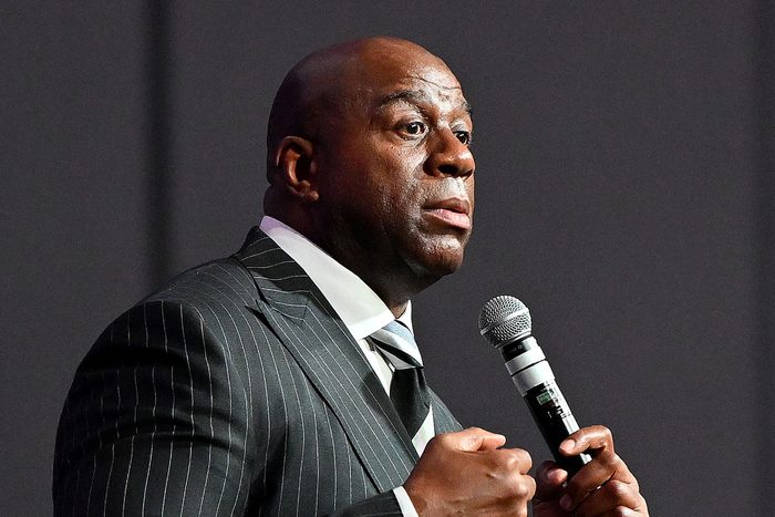 Magic Johnson holding a mircrophone while speaking at a conference