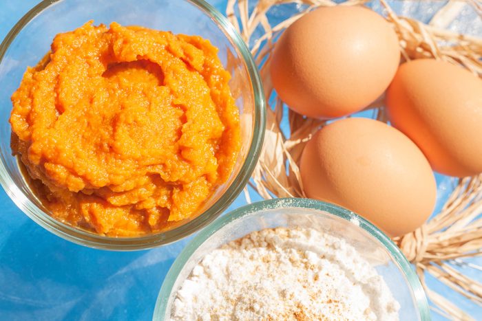 bowl of canned pumpkin, eggs and flour