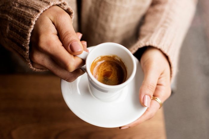 hand holding espresso cup