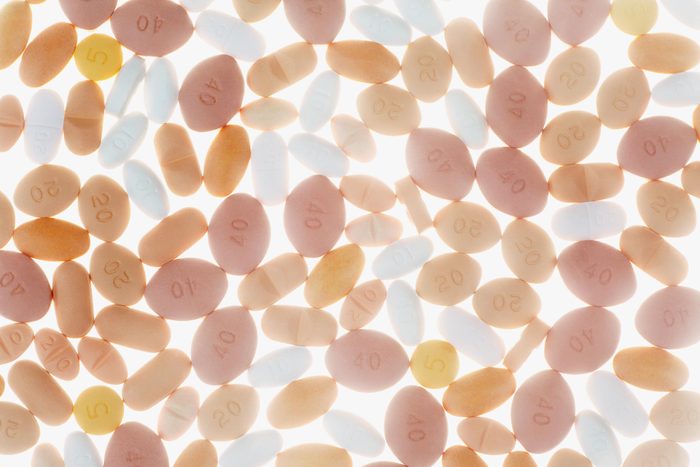 full frame of different colored pills on a white background