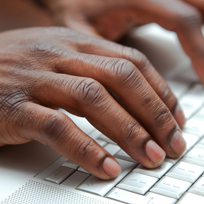 Close up of African hands on a keyboard